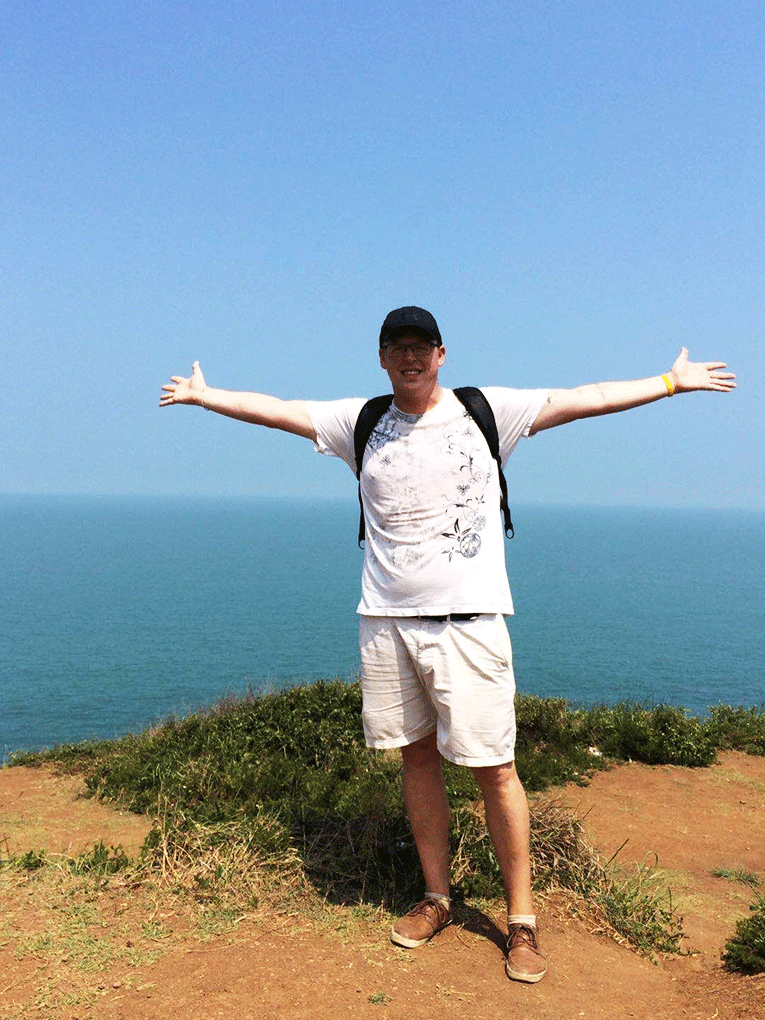 Man posing on trail in front of ocean