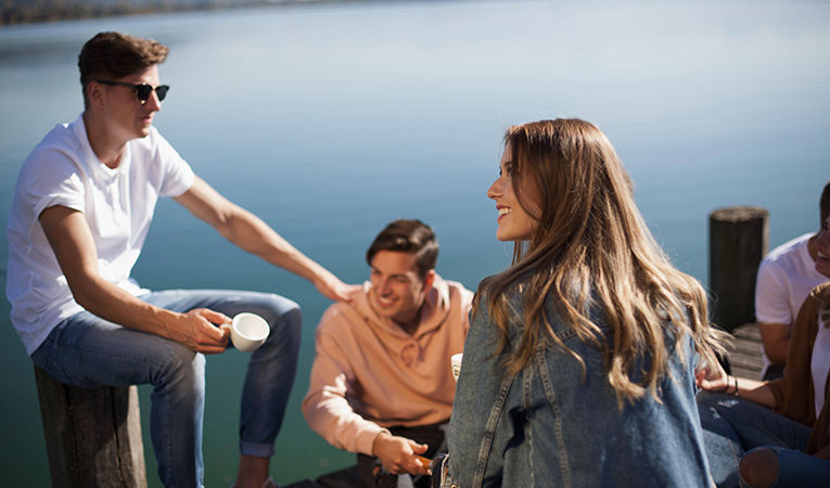 students sitting and laughing together on dock in Switzerland