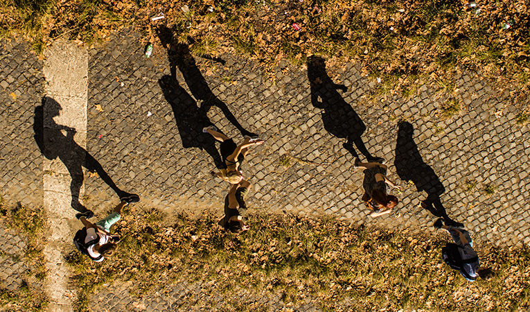 group of students walking in sunlight, aerial photo