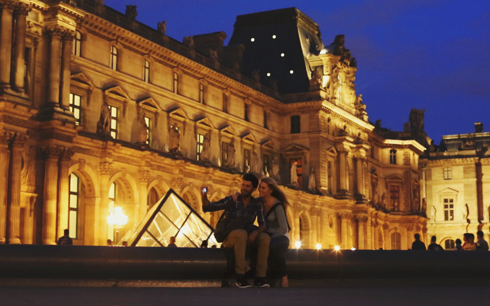 Boy and girl taking selfie at the louvre