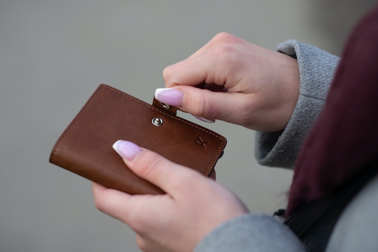 person holding brown wallet