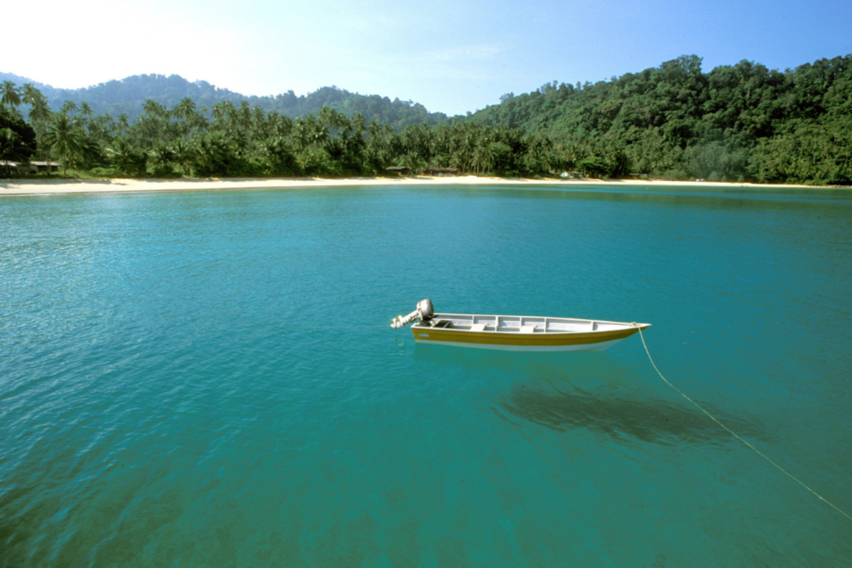 a boat anchored off the coast of Tioman Island in Malaysia