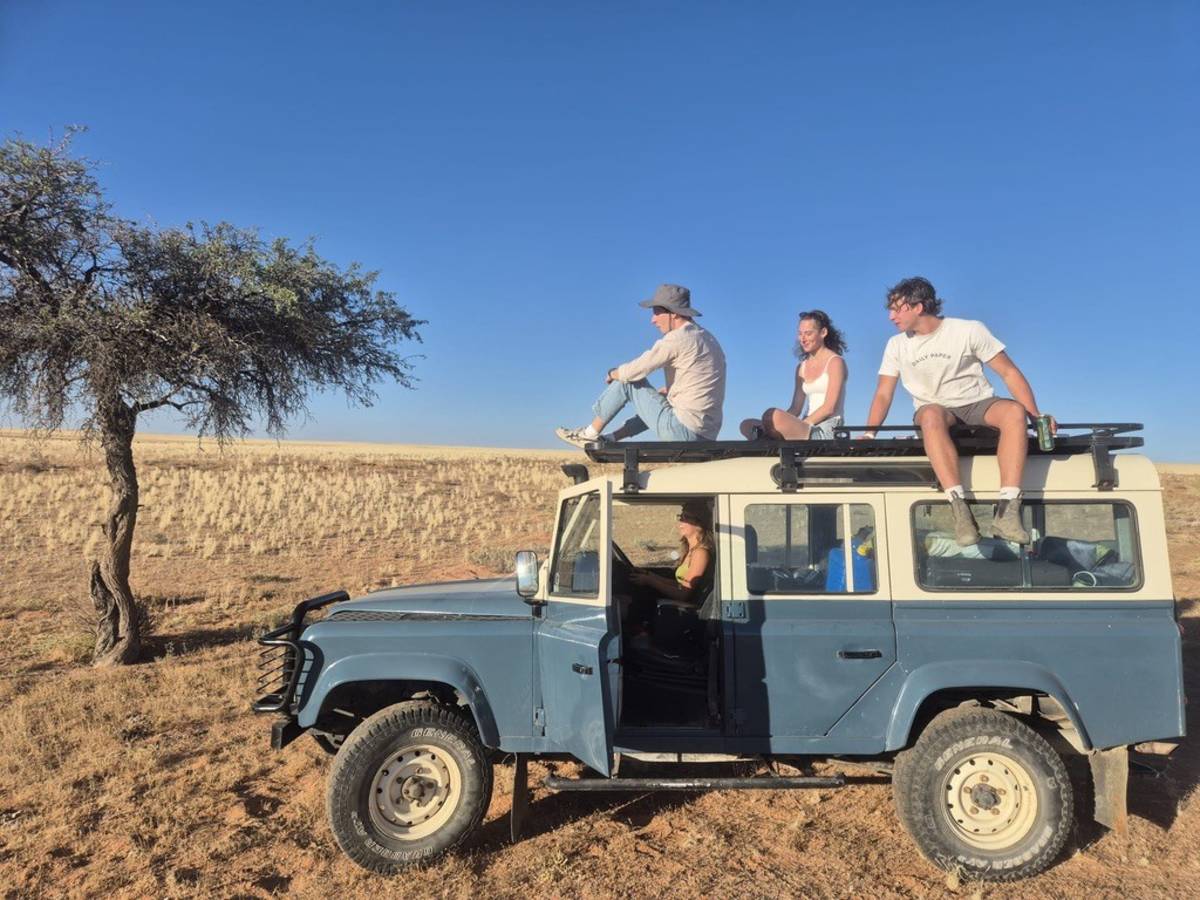 A car with an intern driving and other interns sat on the roof in Aus