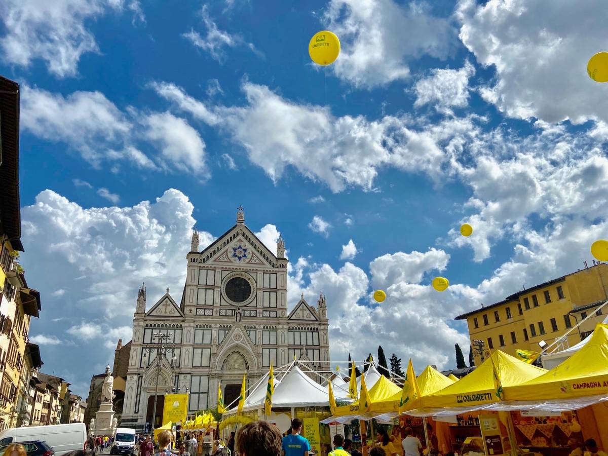 A market in a square with cathedral behind it