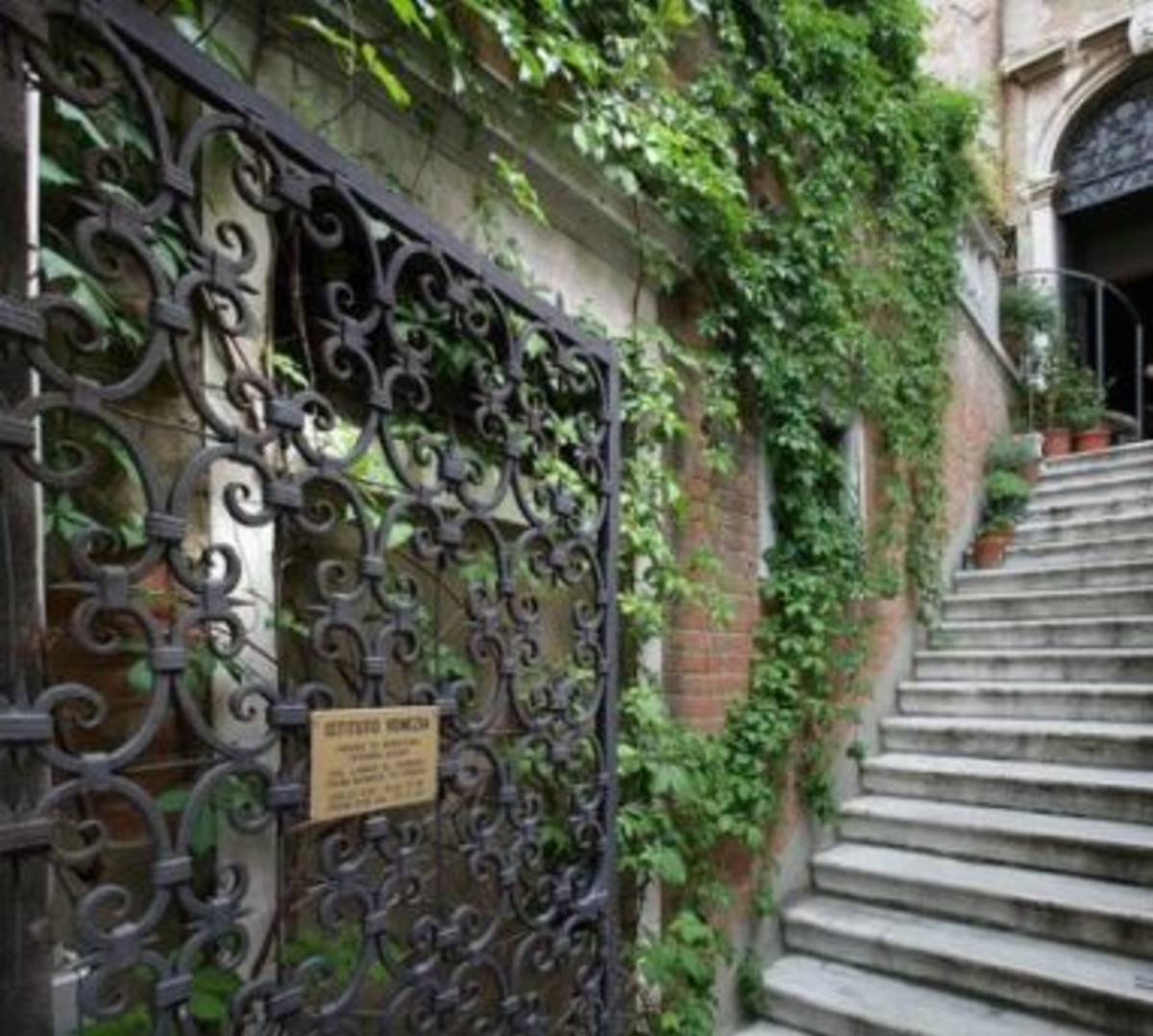A staircase leading to a building covered in ivy.