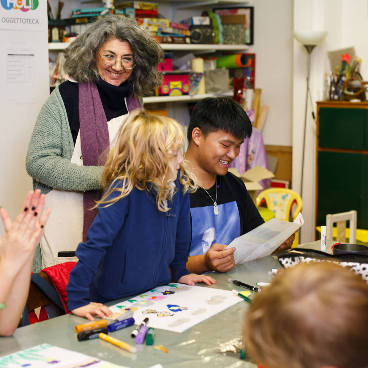 A student coloring with local children.
