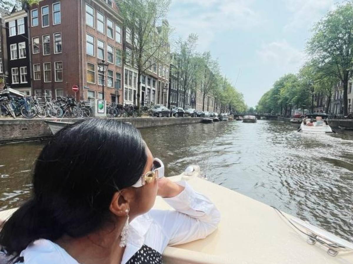 A student looks back at the canal on a boat ride in Amsterdam.