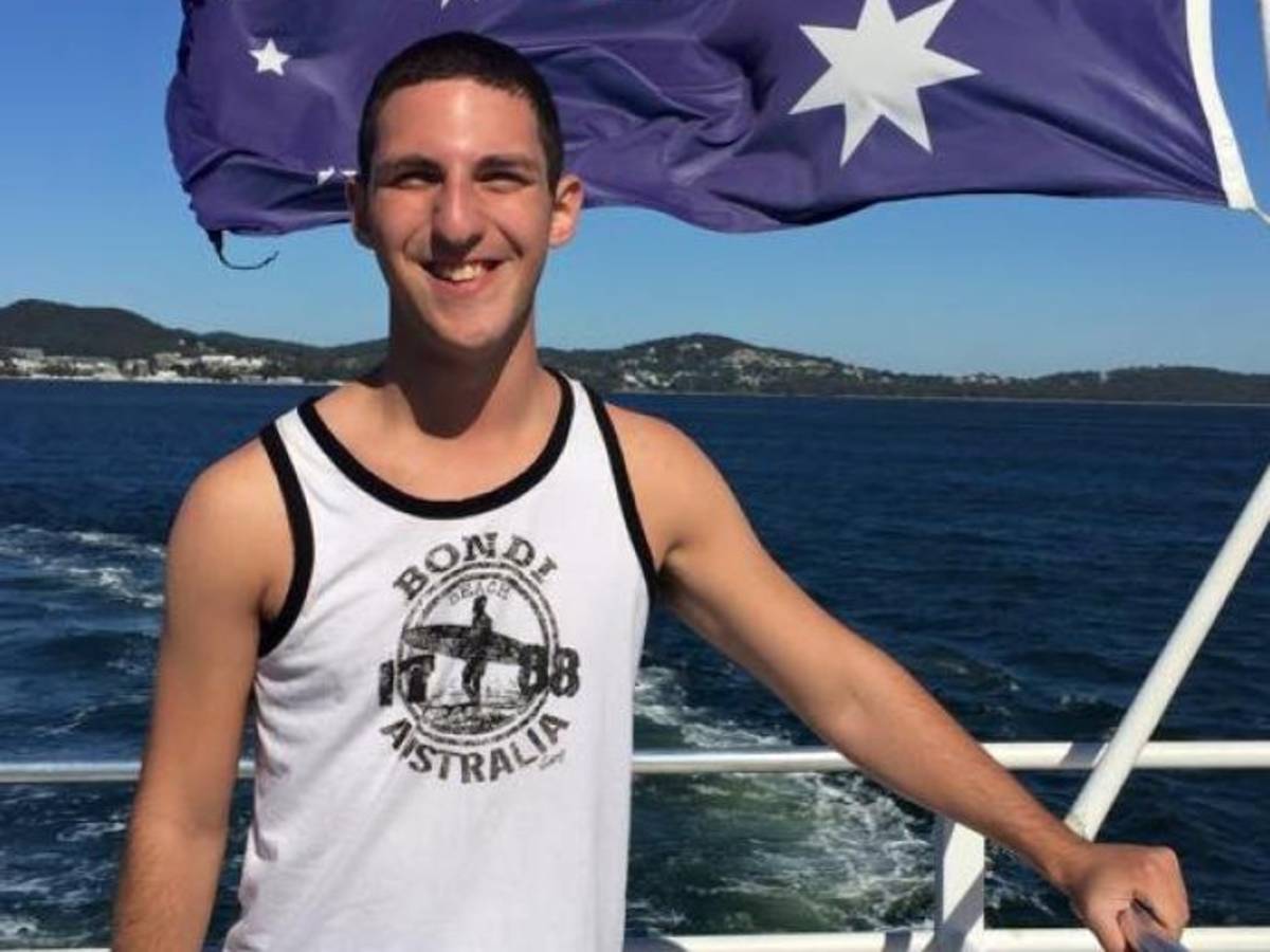 a student on a cruise in Sydney with the Australian flag blowing behind