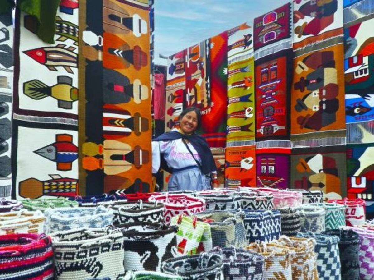 A student stands in a plethora of rugs at a market stand in Ecuador.