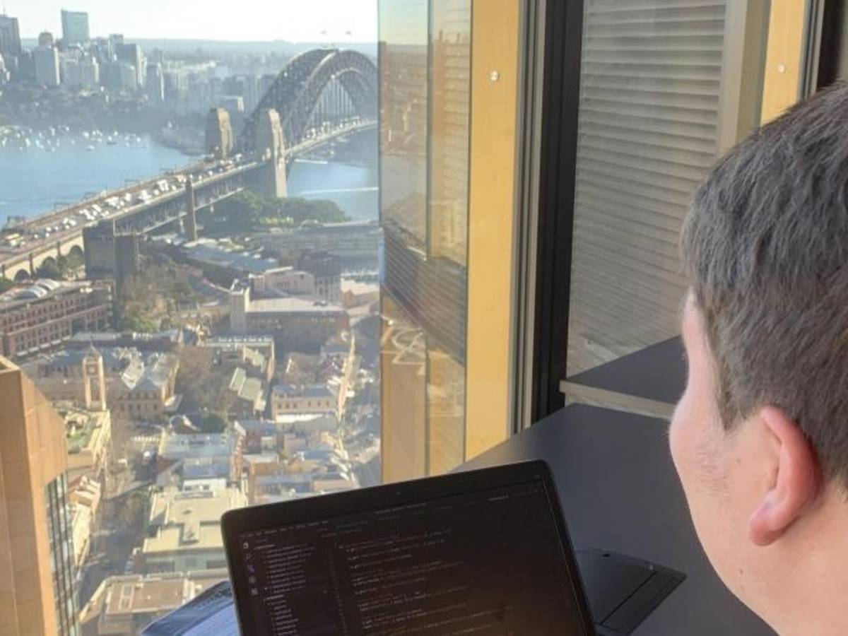 a student working on their laptop overlooking Sydney Harbour Bridge