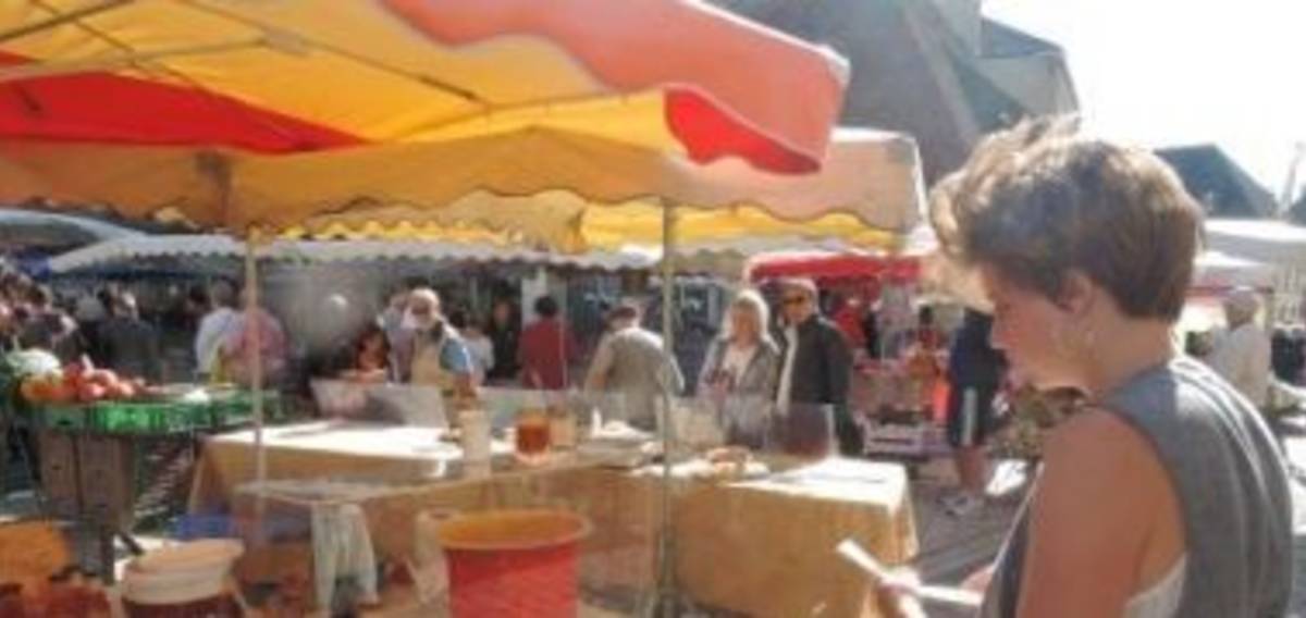 A woman stands in front of a market stall