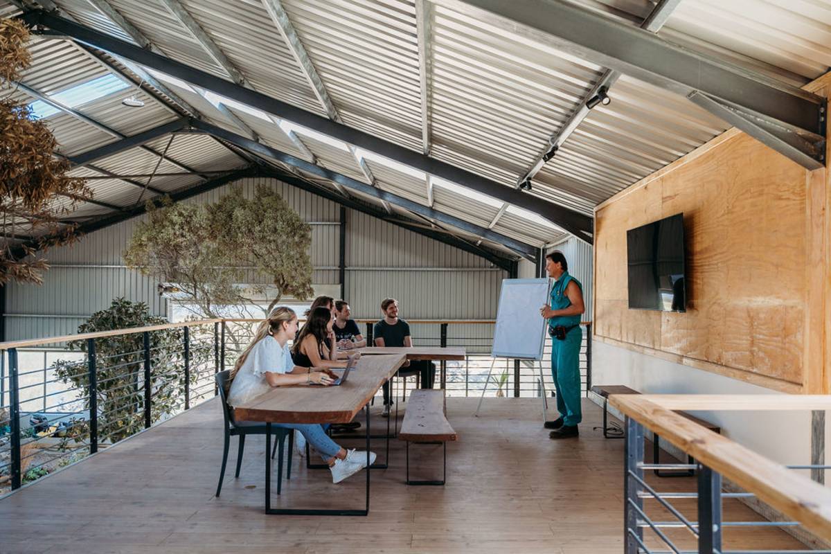 An instructor gives a presentation to people at a table.