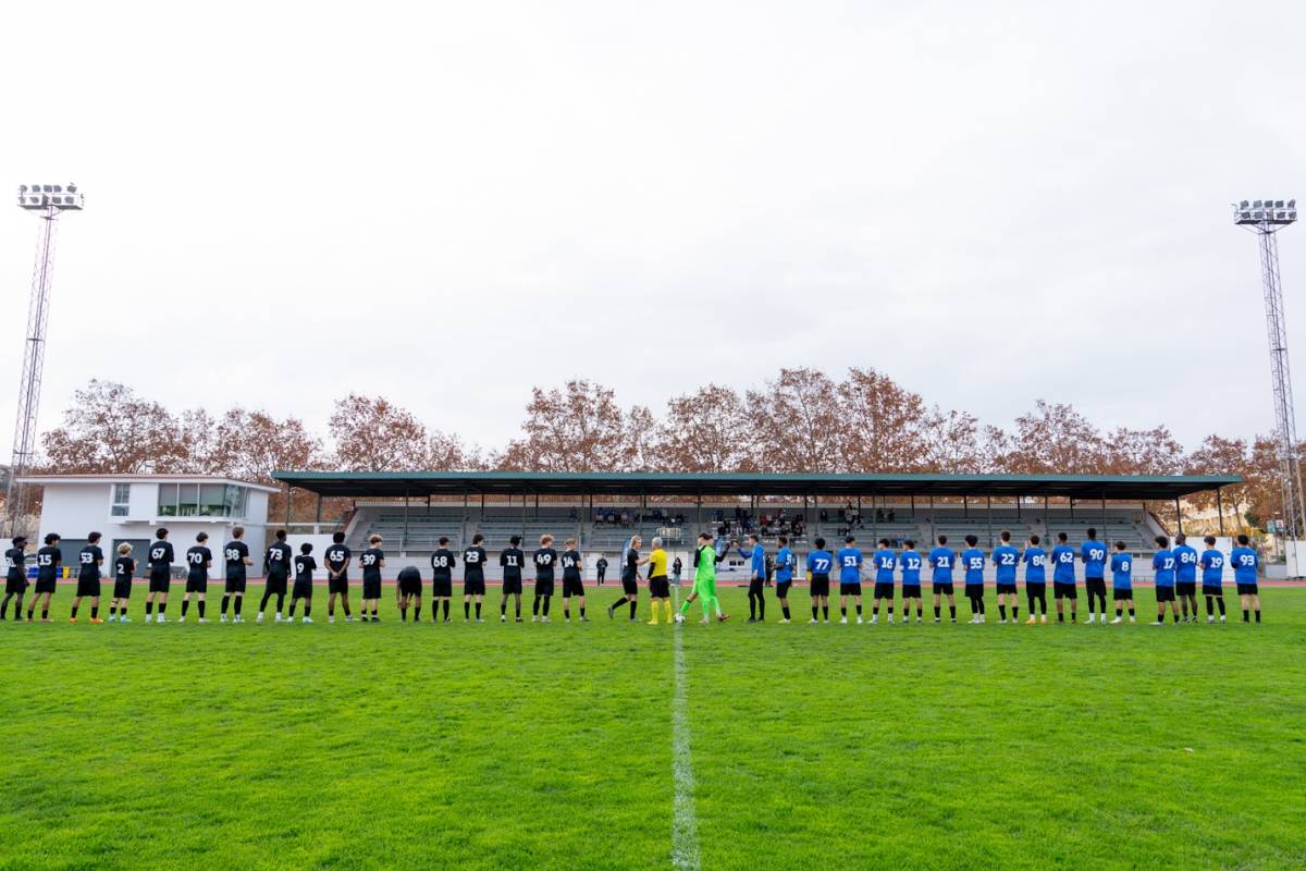 back of soccer players lined up on a soccer field