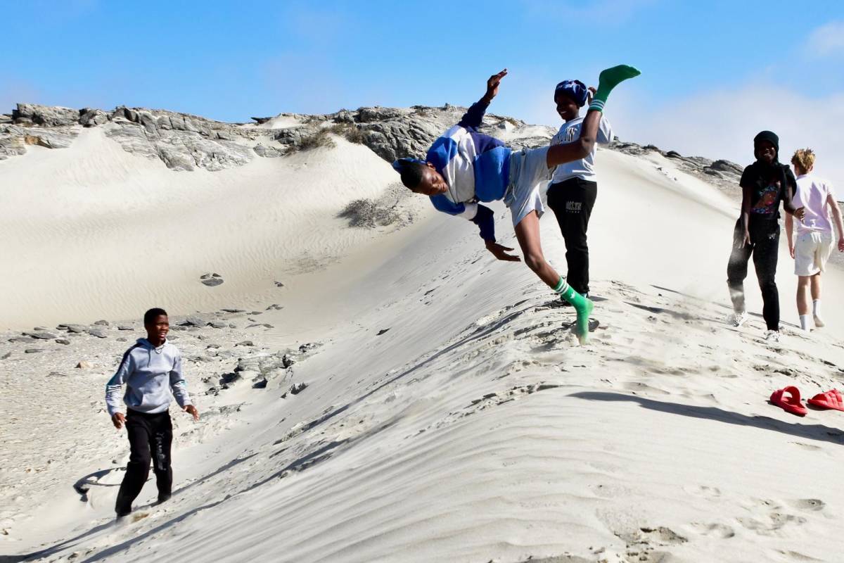 Boarders running down sand dunes at Diaz Point