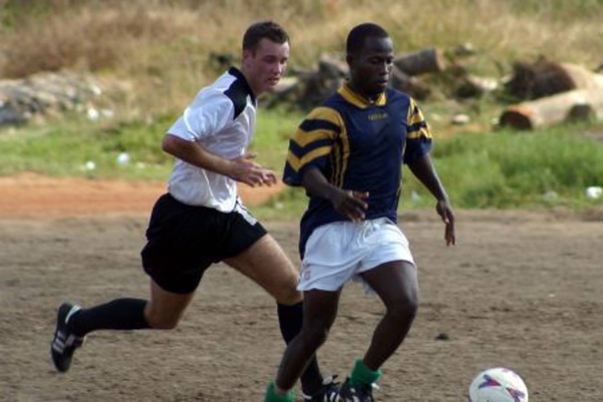 Volunteer playing football with local