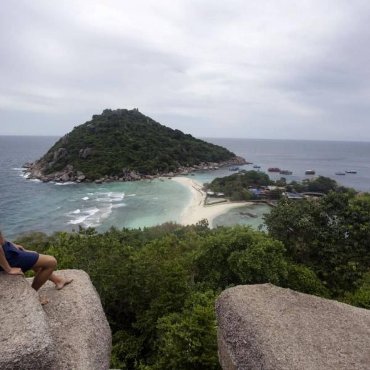 Teen looking out at a coastal landscape in Thailand on a summer travel trip.