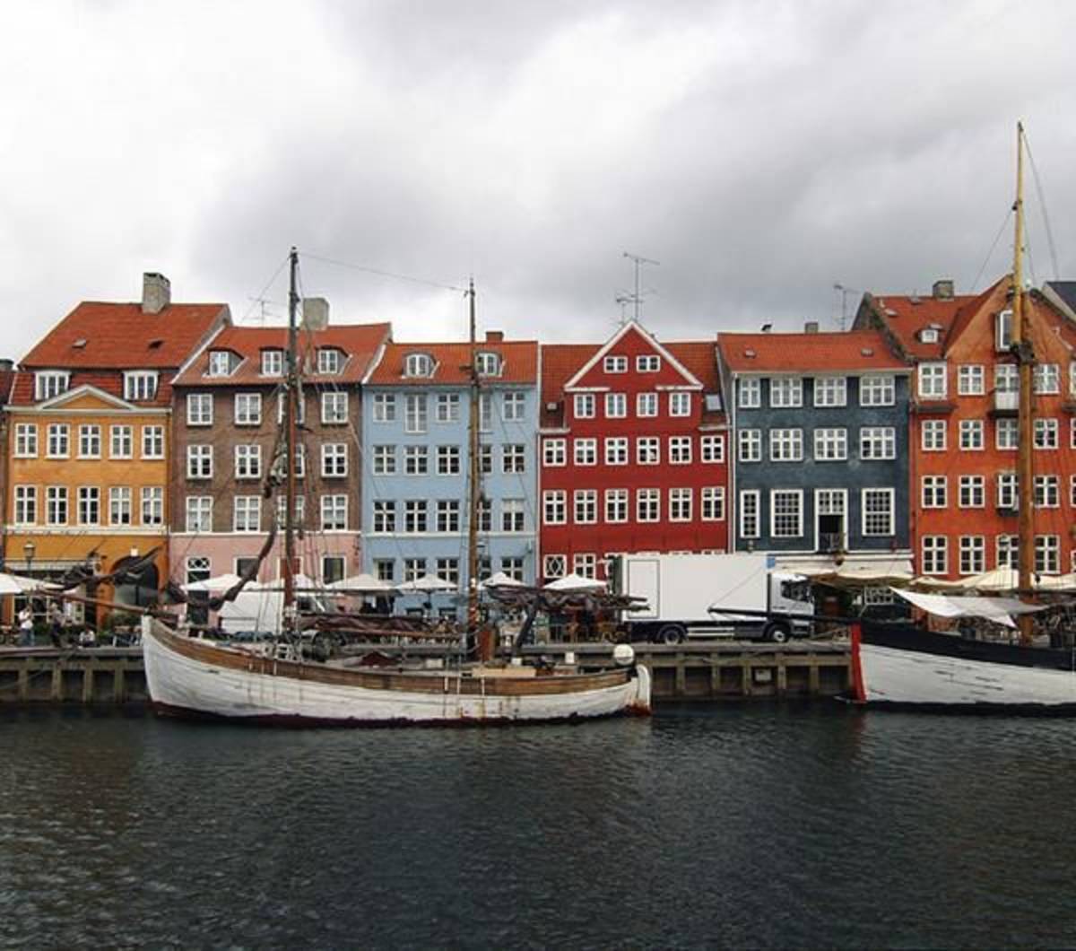 A photo of Danish architecture and boats near a port.