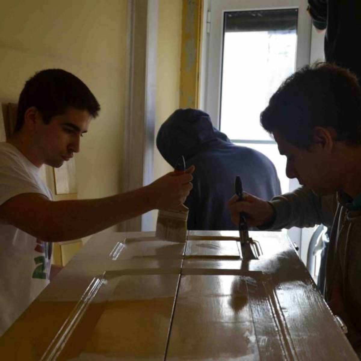 young volunteers painting a door