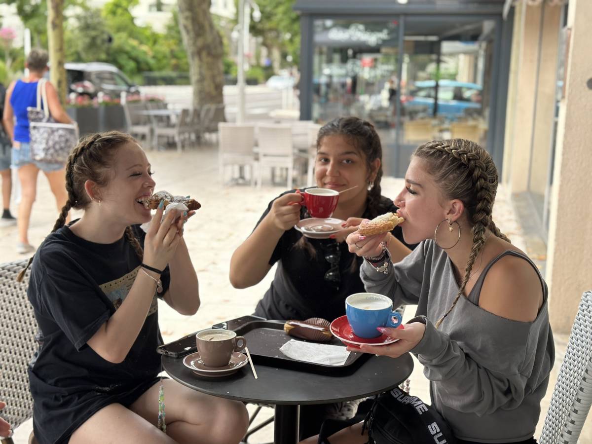 Girls eating croissants and drinking espresso in France