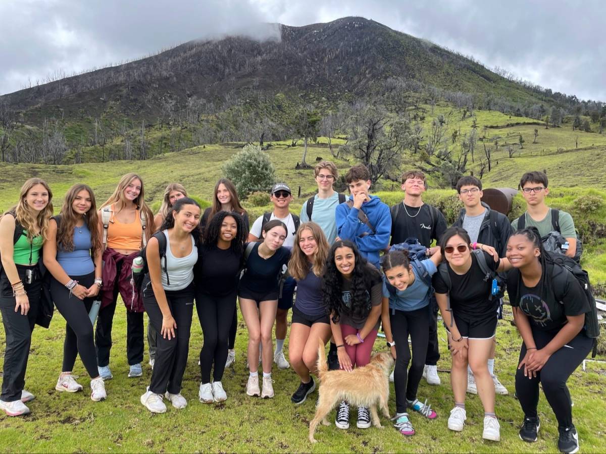 Group of students smiling in front of a mountain