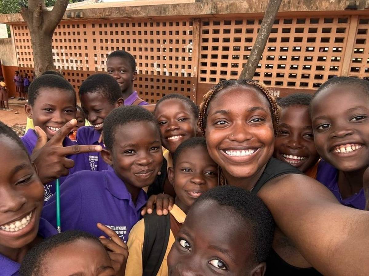 High school student posing with school kids in Legon