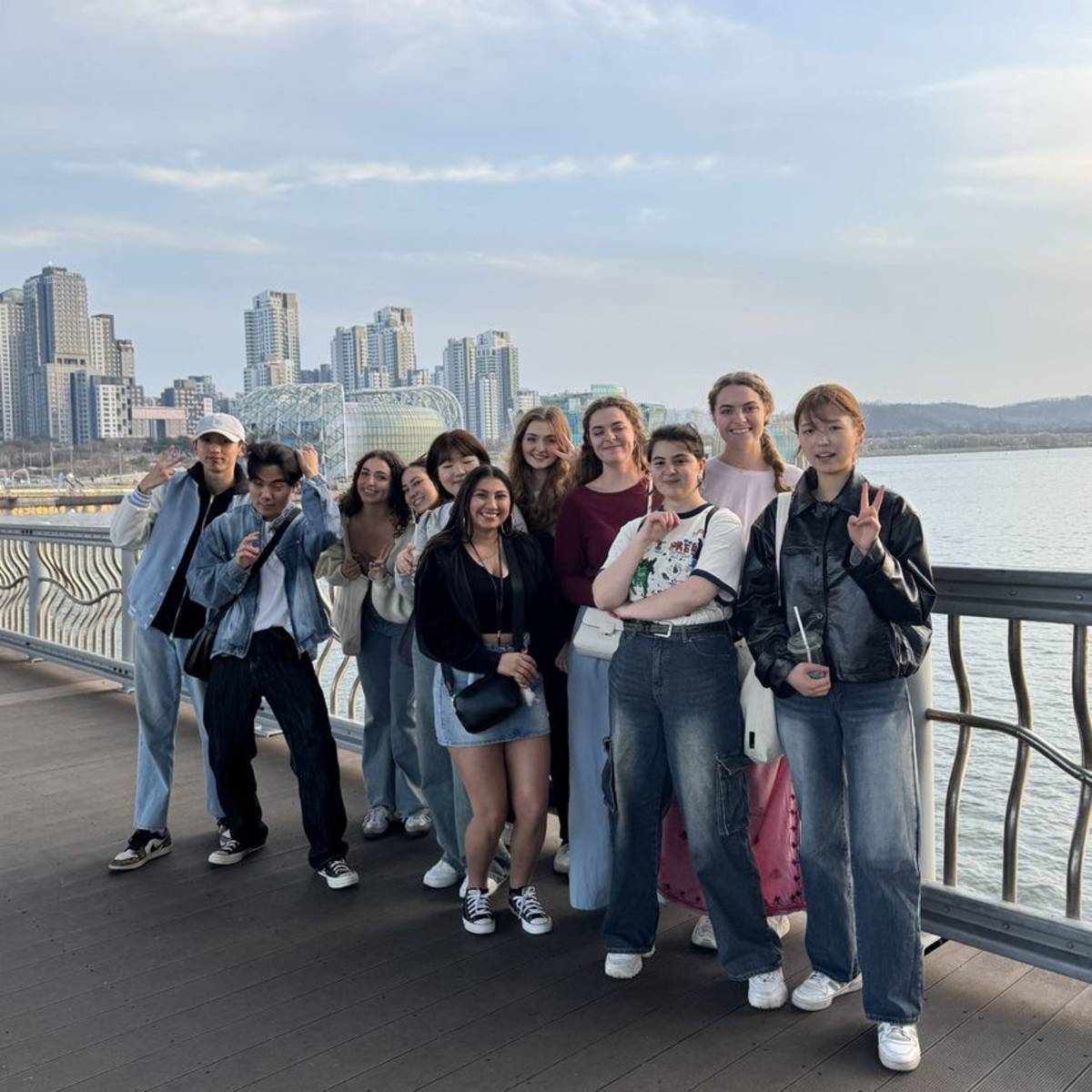 High school students posing with Seoul skyline behind them