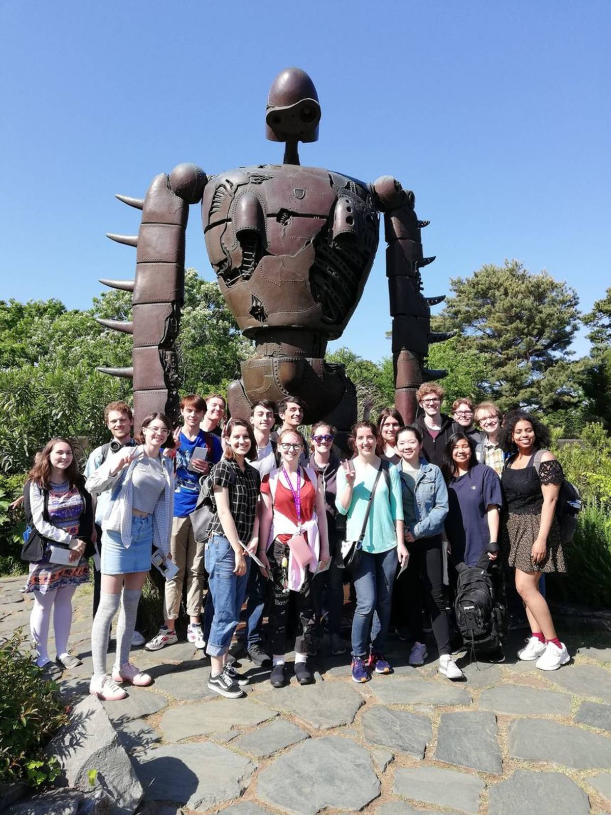 High schoolers posing with giant robot statue