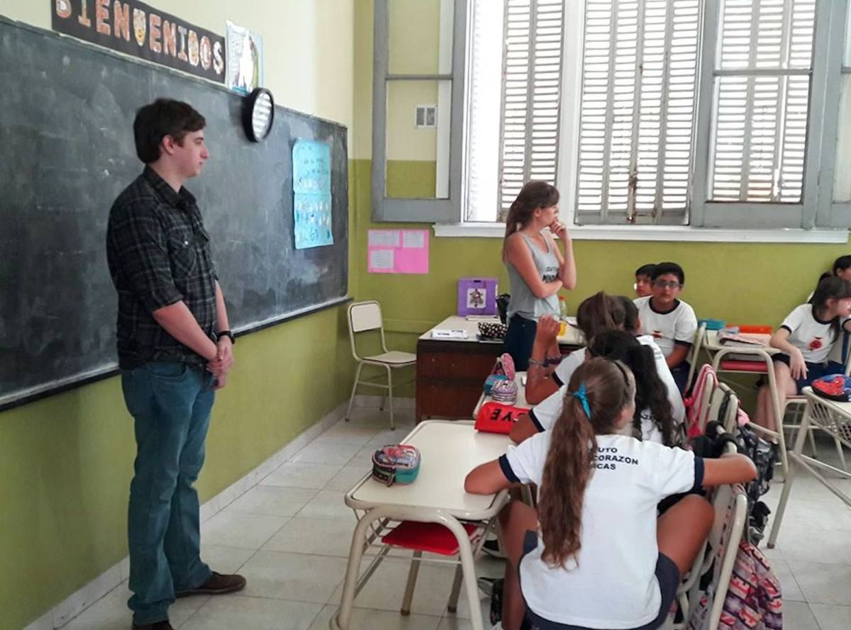 IVHQ Volunteers standing in front of a blackboard teaching students.