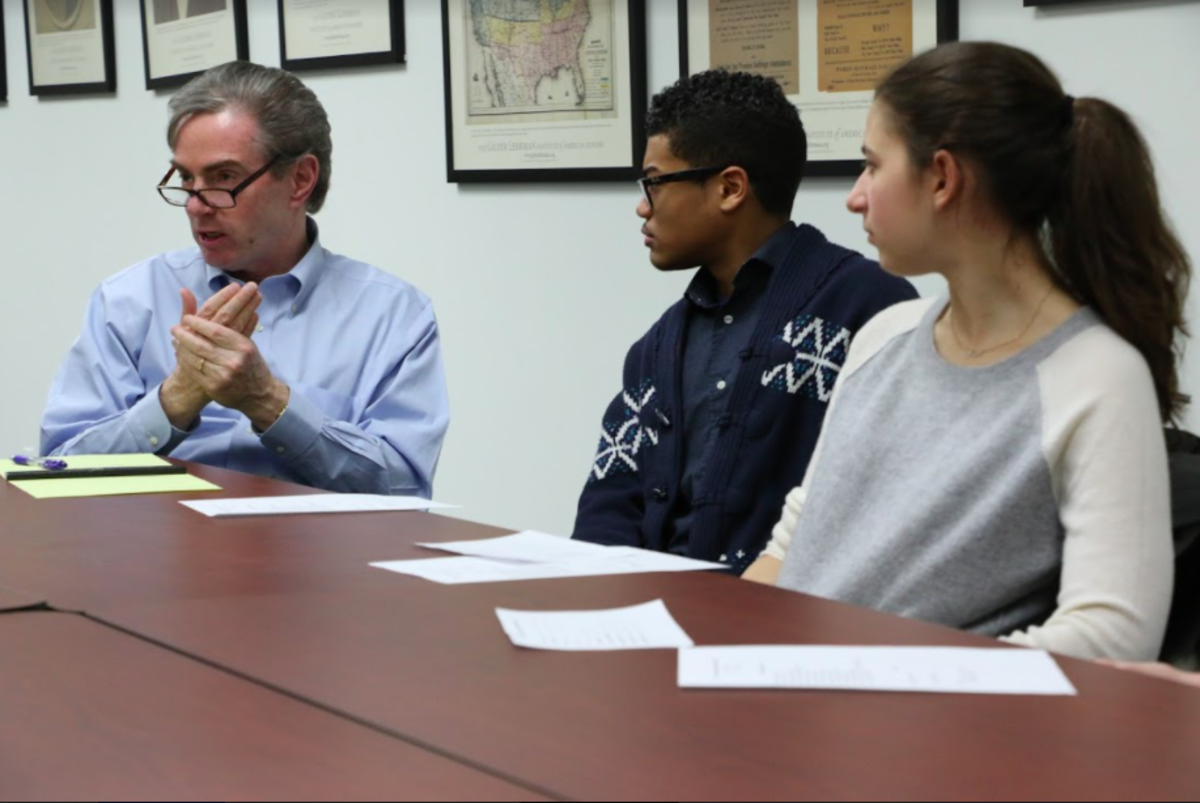 professor james basker sitting with two students in a classroom