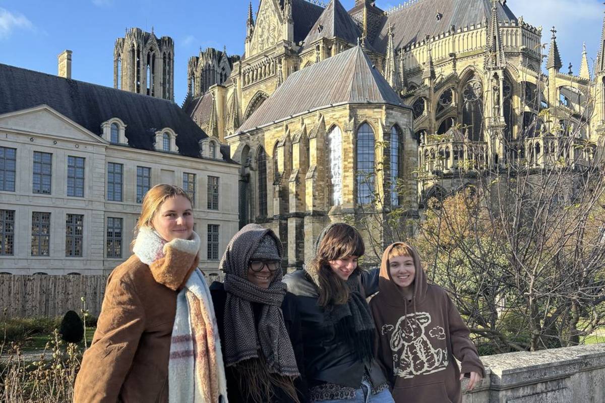 Program participants smiling beside French cathedral