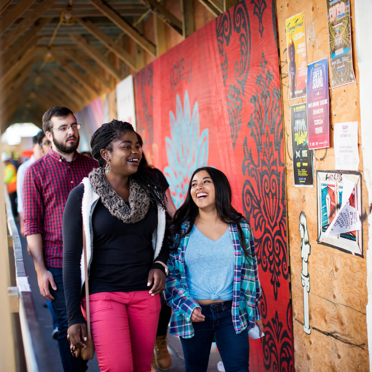 Smiling students admiring paintings.
