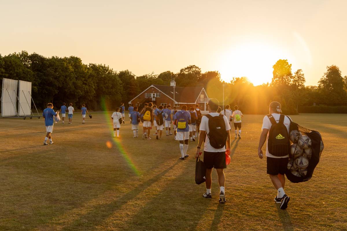 soccer players walking back to the house during sunset