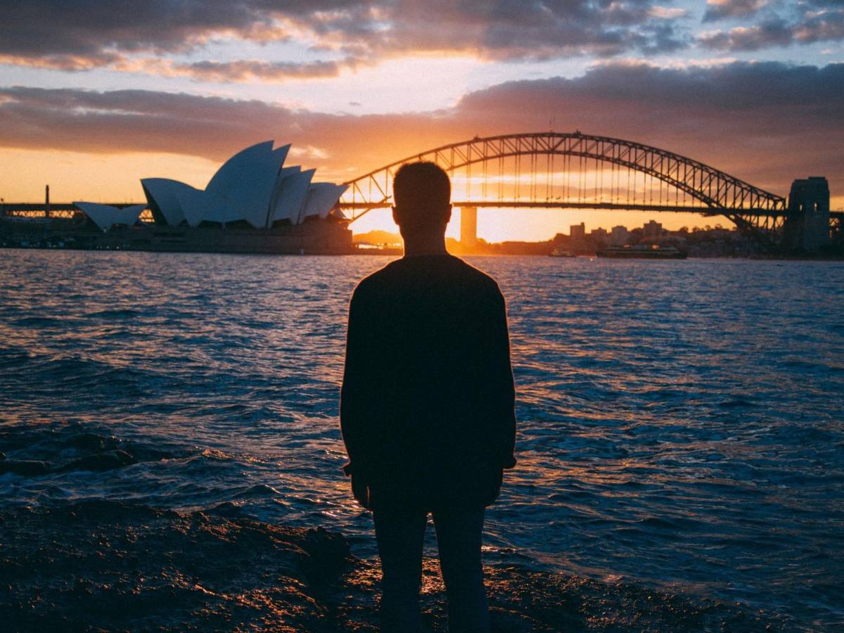 student looking out over Sydney Bridge and Opera House