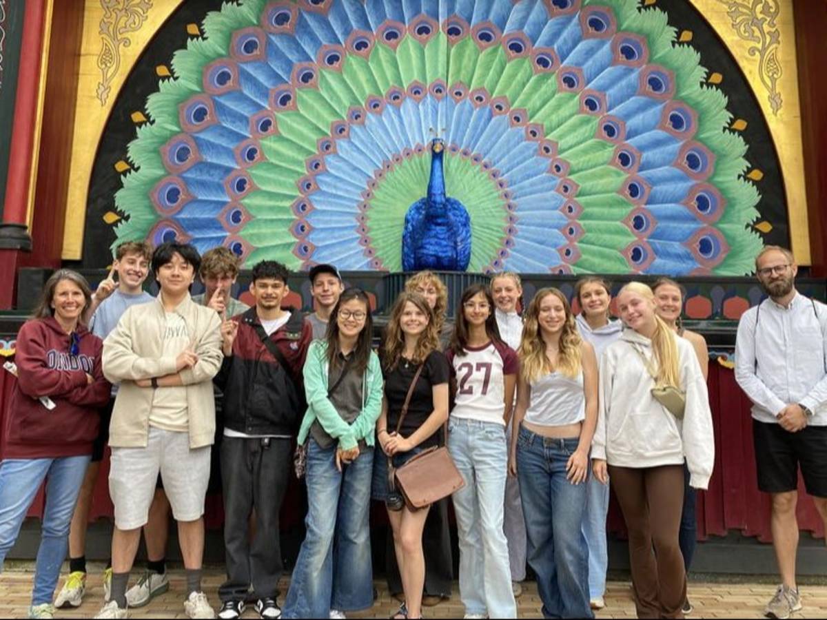 Students and instructors in Copenhagen posing in front of amusement park