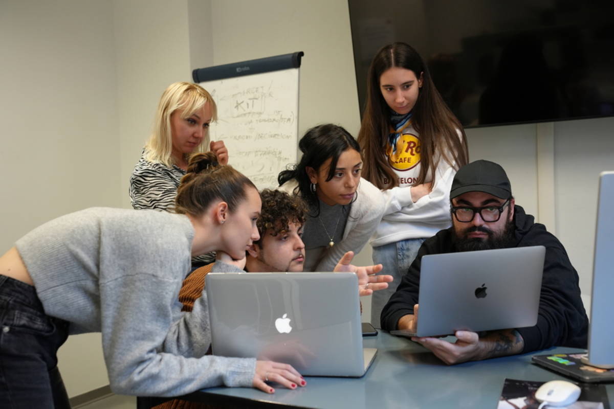Students gathered around 2 laptops in a classroom