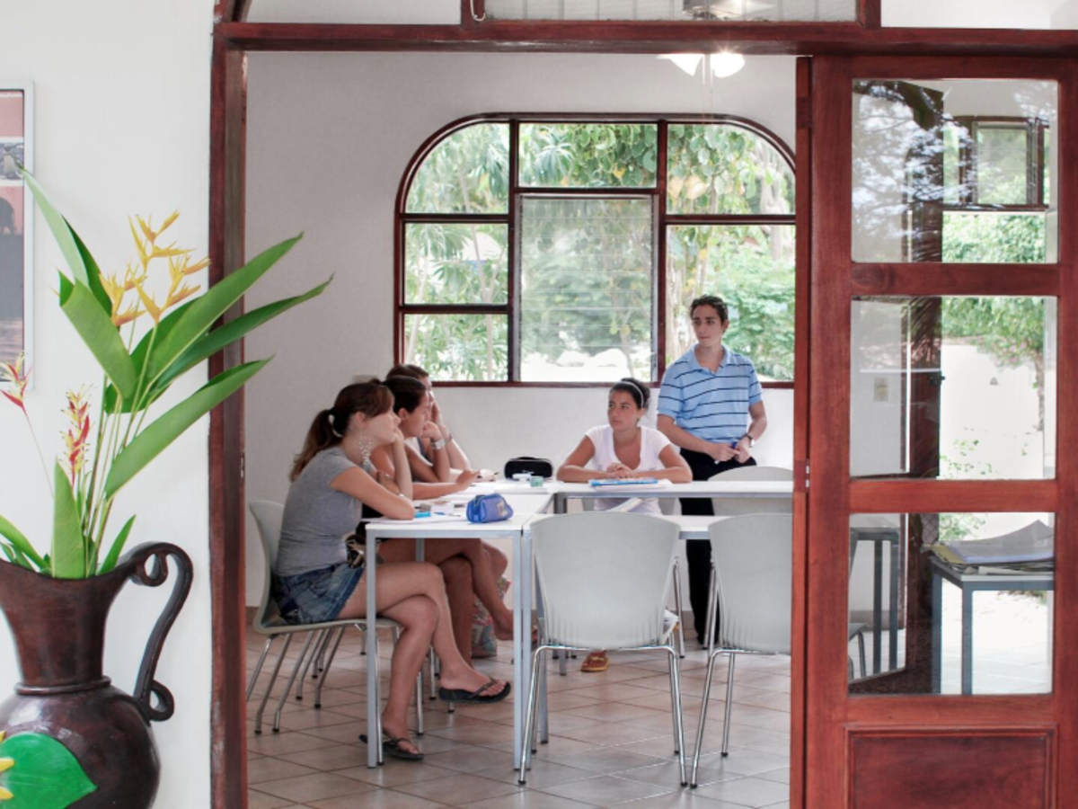 Students in a Spanish language class at EF Playa Tamarindo, Costa Rica, sitting around a table in a bright classroom with large windows.