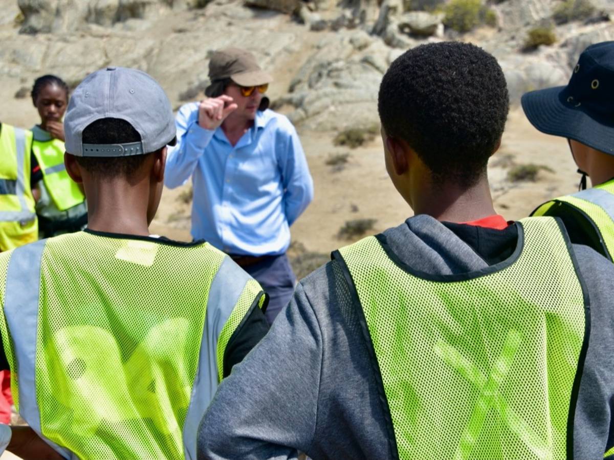Students in hi-vis vests on a coastal field study