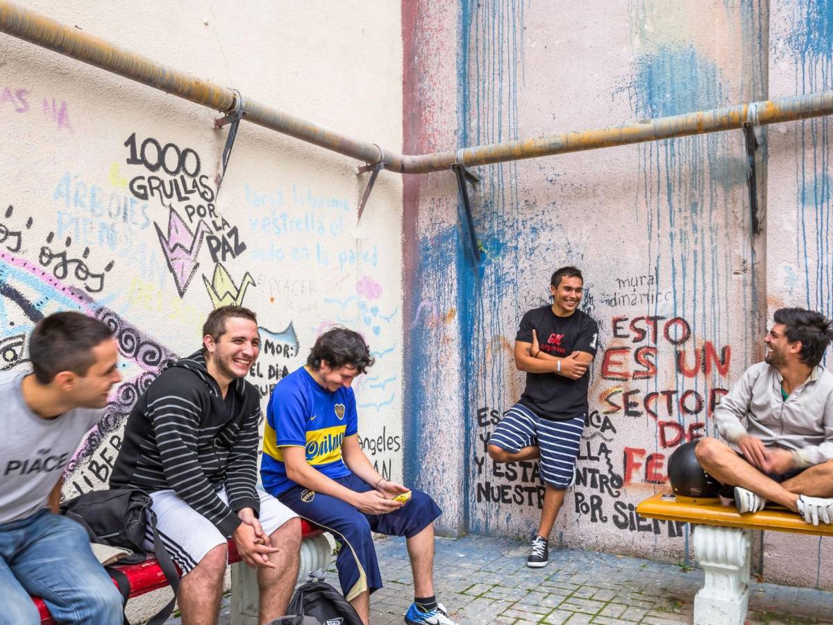 students laughing together while sitting on benches at a local Argentine university