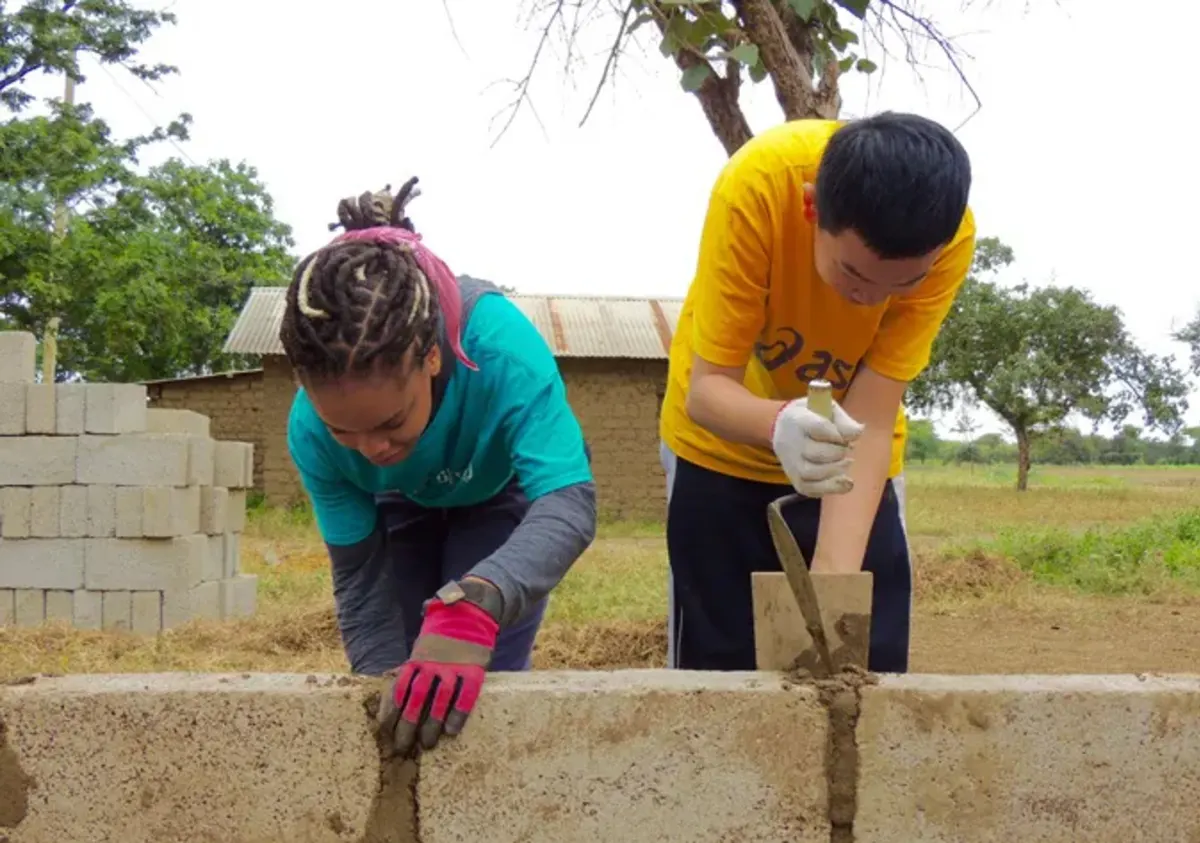 Students lay cinder blocks