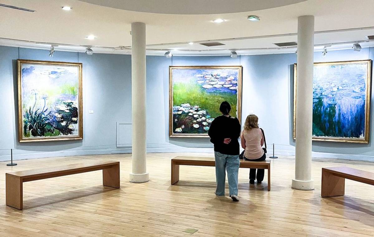 Students looking at Monet paintings in Paris art museum