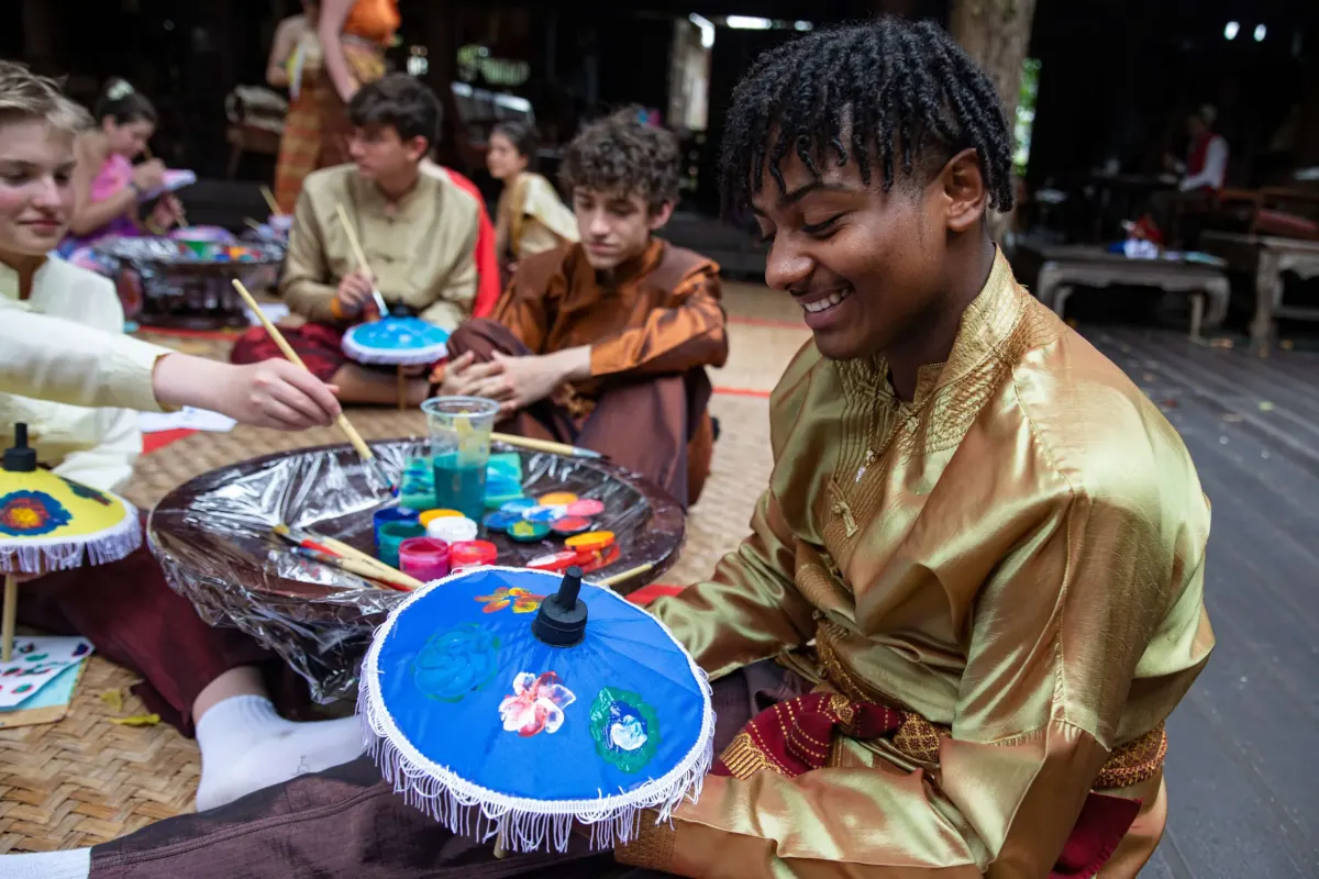 Students paint in traditional local garb