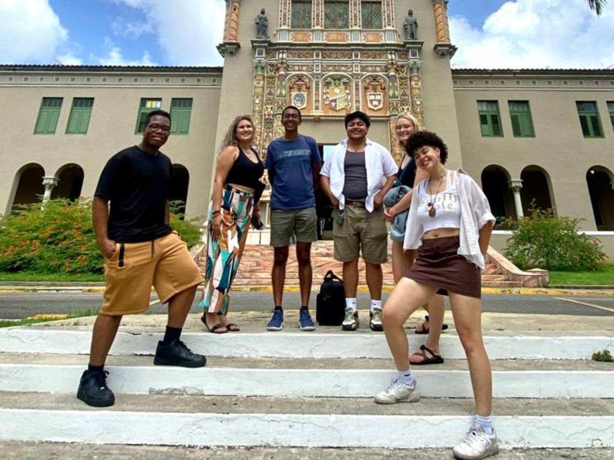 Students pose in front of university building