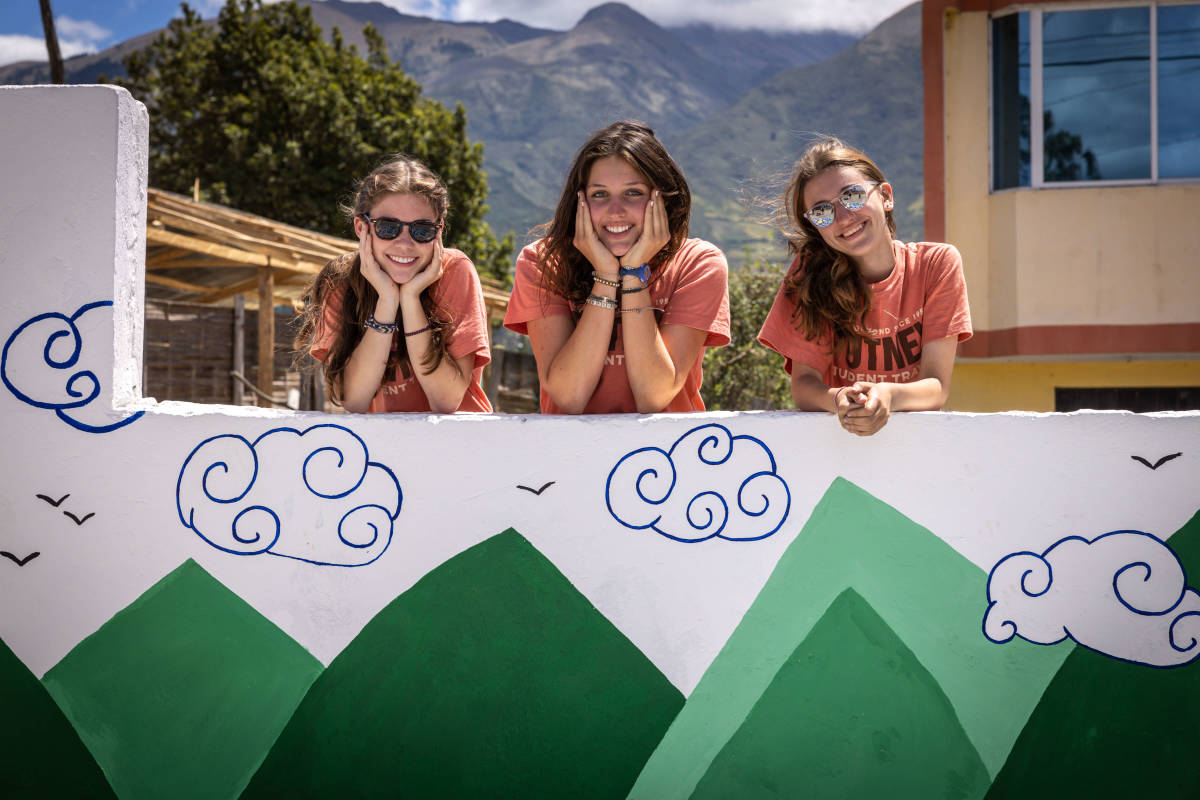 students posing by wall