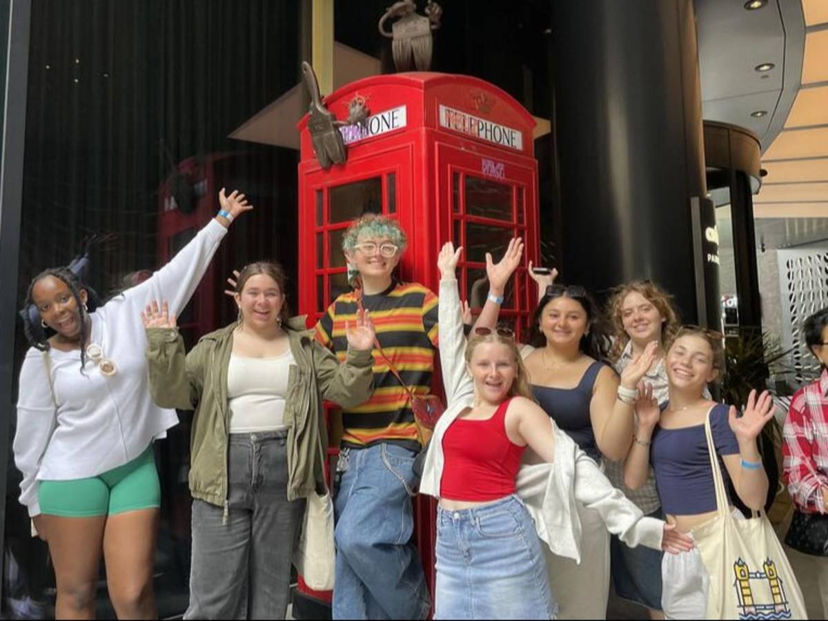 Students posing with phone booth in London