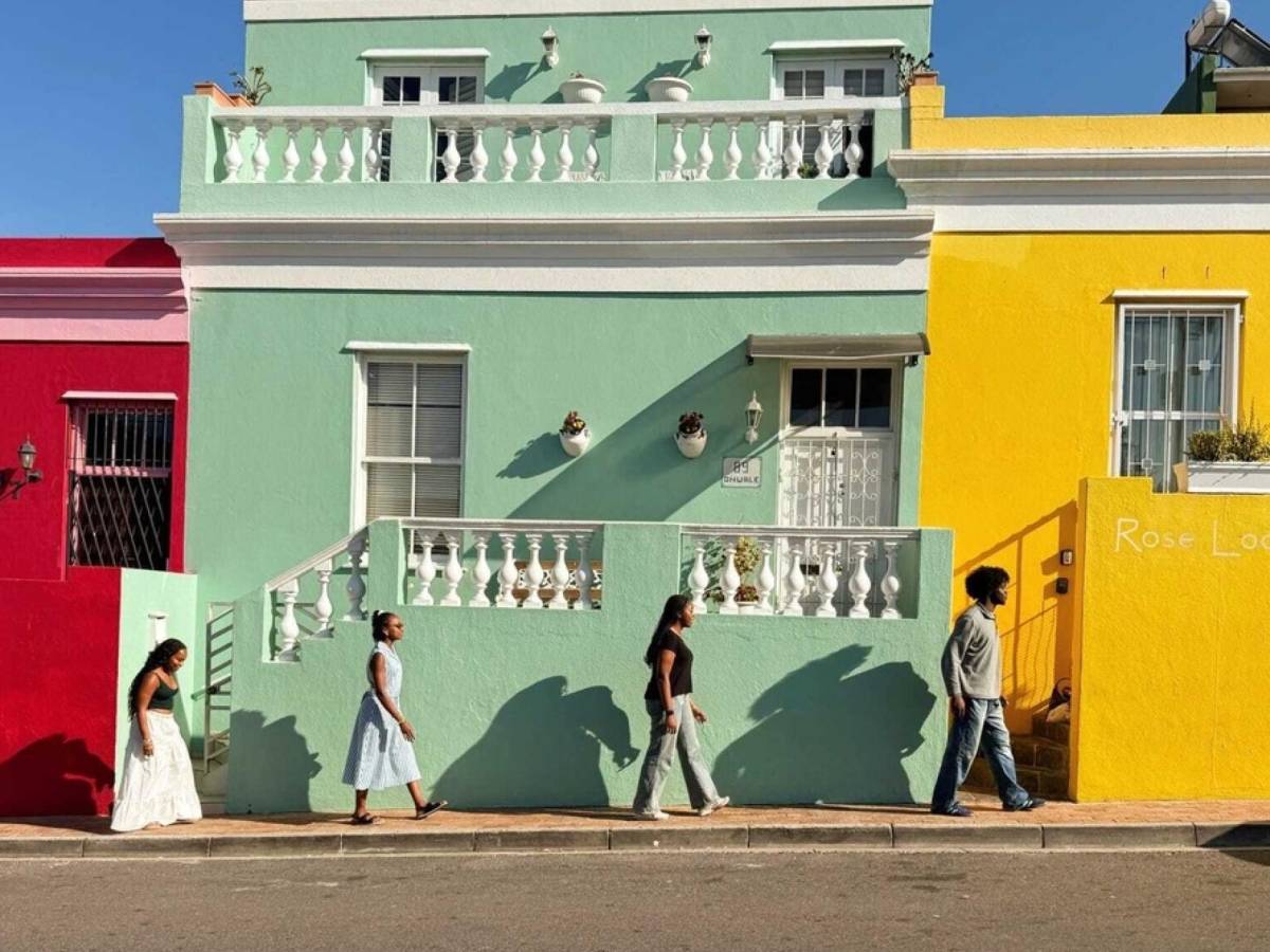 Students walk in front of colorful buildings in Bo-Kaap, Cape Town.
