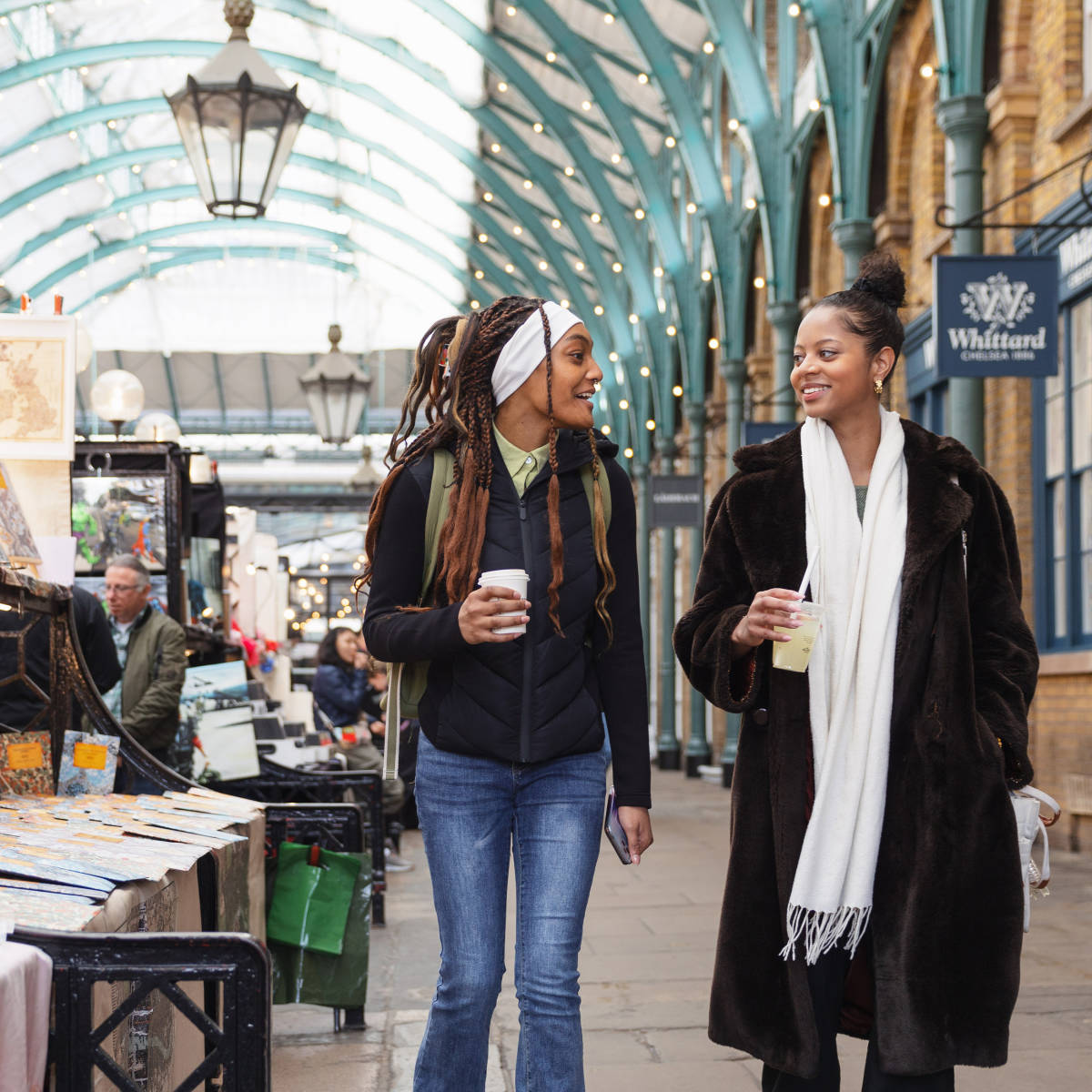 Students with coffee walking in the market.