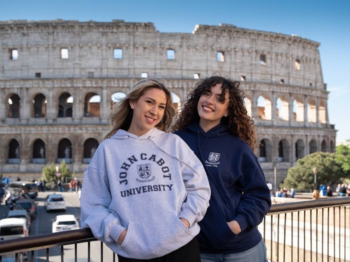 Study Abroad students smiling in front of the Colosseum