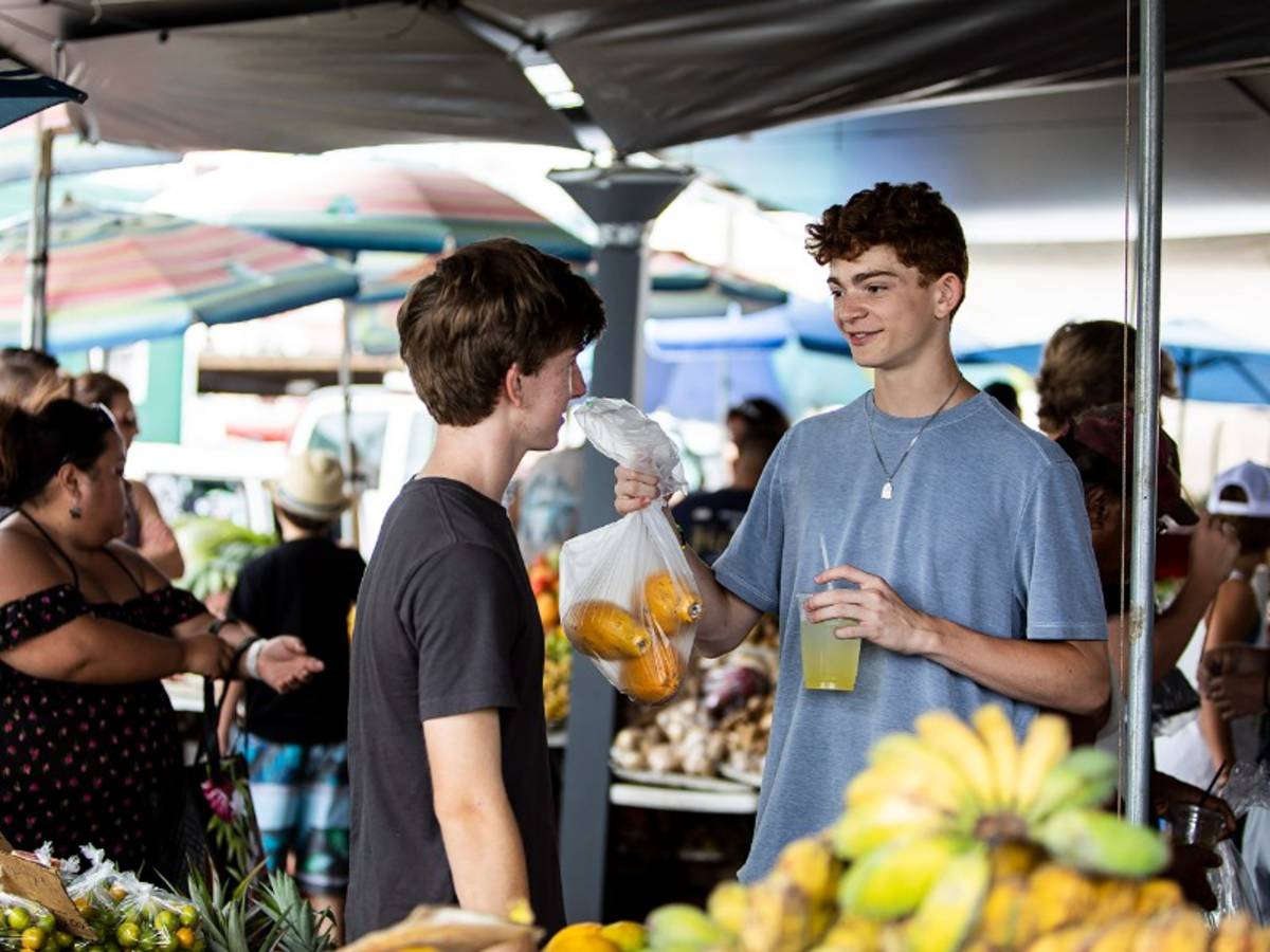 Teen boys shopping for fresh fruit.