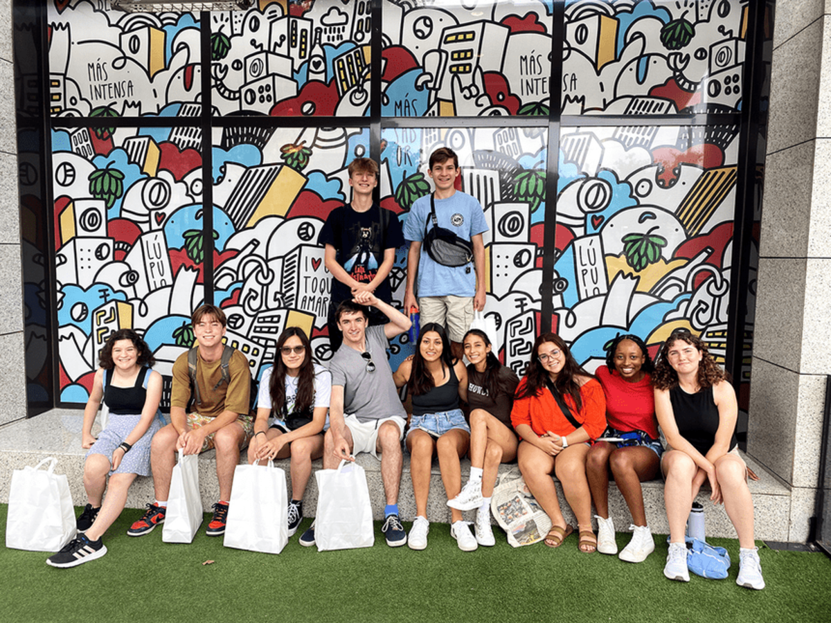 Teenagers on program posing in front of window art in Madrid