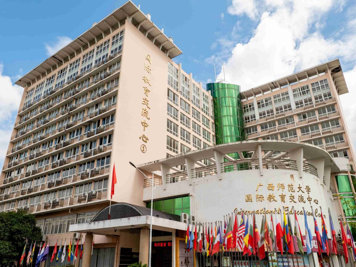 The International Education Center building at Guangxi Normal University in Guilin, with international flags lining the entrance.